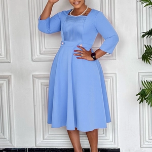 Detail of light blue square neck dress with pleats and a belted high waist design