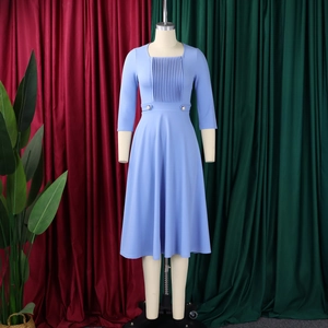 Detail of square neckline and pleated bodice on light blue long sleeve dress with pearl buttons