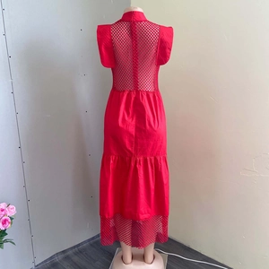 Détail de robe longue rouge avec patchwork en résille au dos et manches à volants fluides
