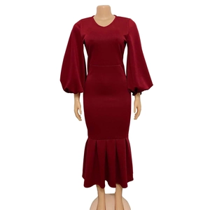 Detail of burgundy V-neck dress featuring oversized lantern sleeves and mermaid hemline