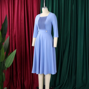 Detail of square neck light blue dress with pleats and pearl buttons on the waistline