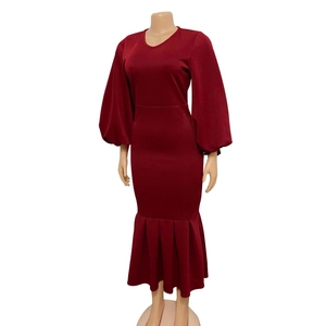 Detail of burgundy V-neck dress featuring lantern sleeves and pleated fishtail hemline
