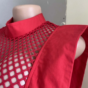 Détail d'une robe trapèze rouge sans manches avec col montant et texture en maille