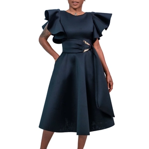 Detail of elegant black dress showing ruffle sleeves and waist belt with golden buckle