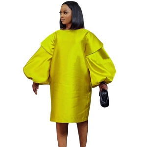 Détail d'une robe vert citron élégante avec des manches lanterne et un fini satiné chic