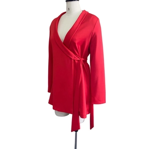 Detail of red wrap dress showing V-neckline, long sleeves and adjustable waist tie