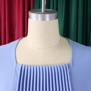 Detail of square neckline and vertical pleats on light blue textured chiffon dress