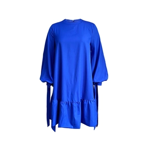 Detail of royal blue lantern sleeves with adjustable tie cuffs on a loose dress