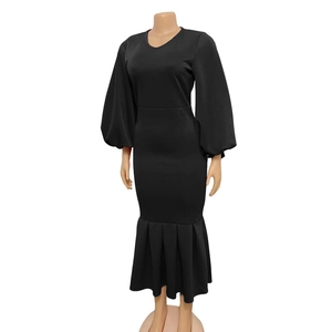 Detail of elegant black V-neck dress featuring lantern sleeves and ruffled fishtail hem