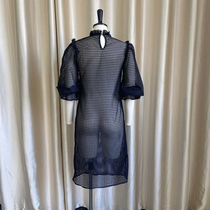 Detail of high collar and mesh texture on black bubble sleeve hollow out dress