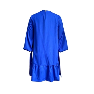 Detail of royal blue A-line dress with puff sleeves and ruffled hem on white background