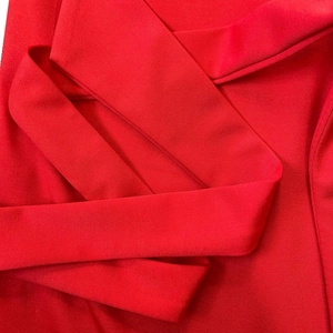 Detailed macro view showing the soft woven texture of the red belted waist tie on a dress