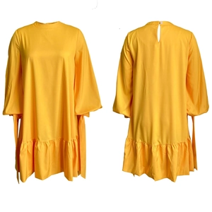 Front and back view of a yellow puff sleeve dress with ruffled hem and cuff ties