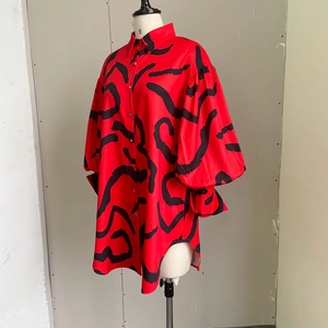 Detail of red oversized shirt dress with black abstract print and lantern sleeve cuffs