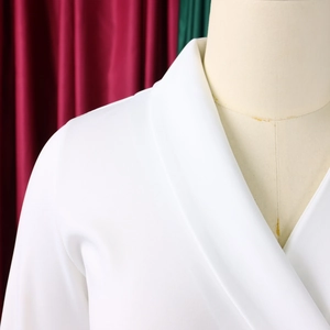 Gros plan du col en V élégant et du tissu blanc texturé de cette robe crayon chic