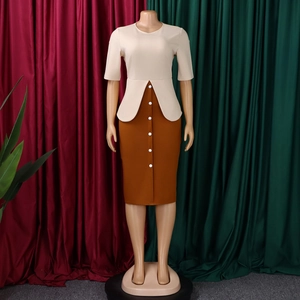 Détail de la taille à basque et des boutons décoratifs blancs sur la jupe de la robe