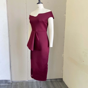 Détail d'une robe bordeaux moulante avec col bateau et décoration volantée à la taille