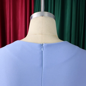 Detailed view of square neckline with invisible zipper on light blue textured dress