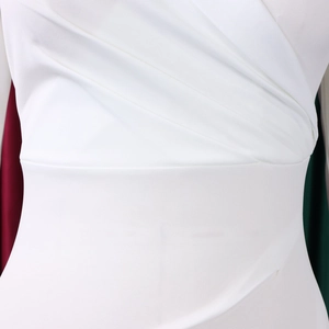 Détails de robe blanche avec drapés superposés et structure amincissante à taille haute