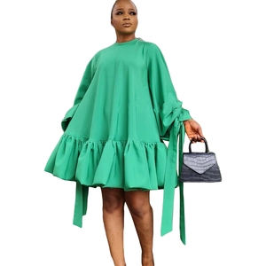 Detail of green puff sleeve mini dress featuring ruffled hem and ribbon cuff accents