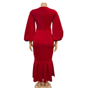 Detail view of red V-neck maxi dress featuring puff sleeves and fishtail hem with back zipper