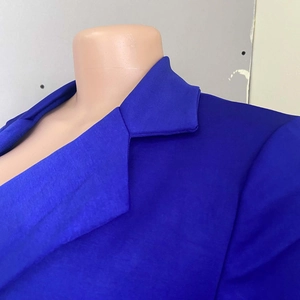 Dettaglio del colletto e della spalla di un blazer blu reale su un manichino