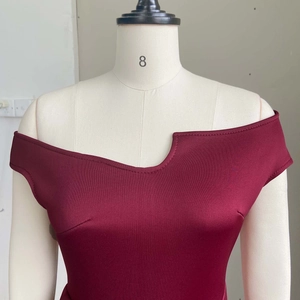 Détail de robe bordeaux avec décolleté asymétrique et texture satinée de haute qualité