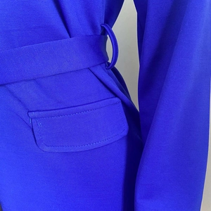 Dettaglio di un abito blu reale con tasca a patta e cintura in vita coordinata