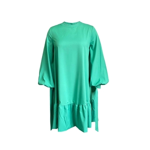 Close-up of emerald green puff sleeves and ruffle hem detail on this loose midi dress