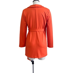 Back view of a vibrant orange long-sleeved mid-length blazer dress with waist tie belt