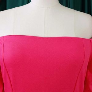 Detail of fuchsia ribbed knit fabric texture on an off-shoulder bodycon dress