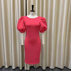 Détail de la robe de cocktail moulante rose vif avec manches bouffantes et col rond
