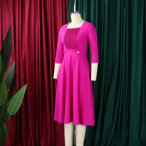 Detail of square neckline with vertical pleats and white buttons on a rose red dress