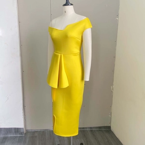 Détail de la robe moulante jaune avec décolleté asymétrique et volants à la taille