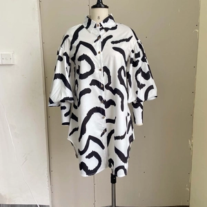 Detail of black and white abstract print shirt dress with puff sleeves and metal buttons