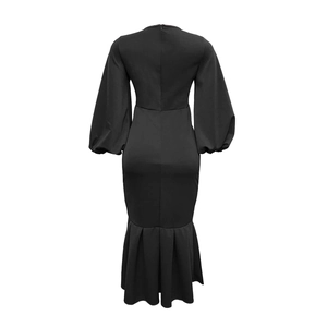 Detail of elegant black V-neck dress with fishtail hem and stylish puff long sleeves