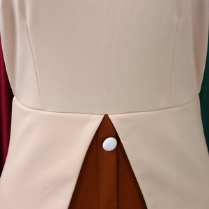Détail de la taille d'une robe beige avec épissure marron et bouton blanc décoratif