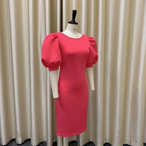 Gros plan d'une robe mi-longue rose rouge ajustée avec manches bouffantes et col rond