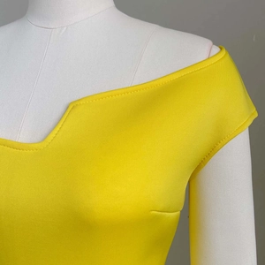 Détail du décolleté jaune à épaules dénudées avec des finitions à double couture