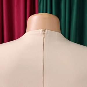 Détail du dos d'une robe beige avec fermeture éclair invisible et texture de tissu élégant