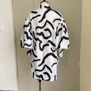Detail view showing oversized silhouette and abstract black lines on white shirt dress