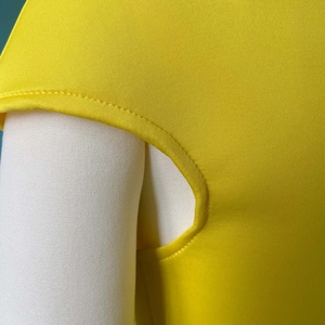 Gros plan détaillé des coutures précises et de la texture en maille d'une robe jaune