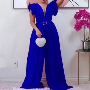Detail of royal blue jumpsuit showing deep V-neck, ruffle shoulders and gold buckle belt