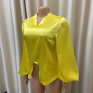 Dettaglio di una camicetta in raso giallo brillante con scollo a V e maniche a lanterna