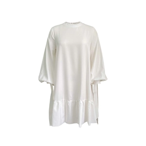 Detail of white satin dress with puff sleeves and elegant ruffled hemline finish