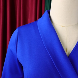 Détail du col et de l'épaule d'un blazer bleu roi sur un support de mannequin