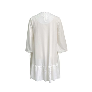 Detailed view of white long sleeve satin dress with pleated ruffle hem and back button