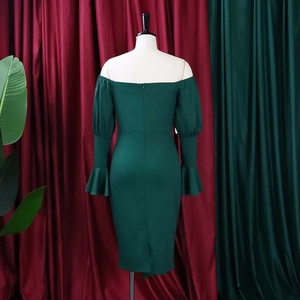 Close-up of the elegant off-shoulder neckline and flared sleeve detail on a dark green dress