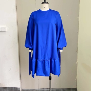 Close-up of lantern sleeves with cuff ties and ruffled hem on a blue dress