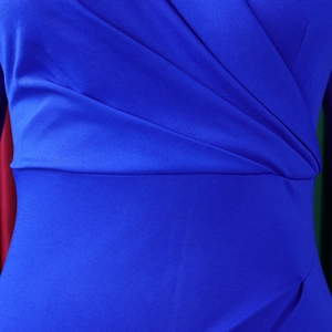 Détail de la robe bleu roi à col en V montrant les plis à la taille et la texture du tissu